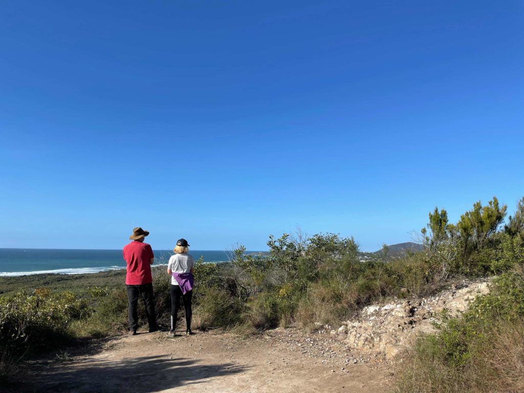 People looking out over the pacific ocean on the way up Emu Mountain 