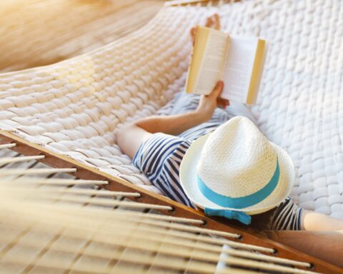 Man relaxing on a hammock with a book. Bookshop Noosa