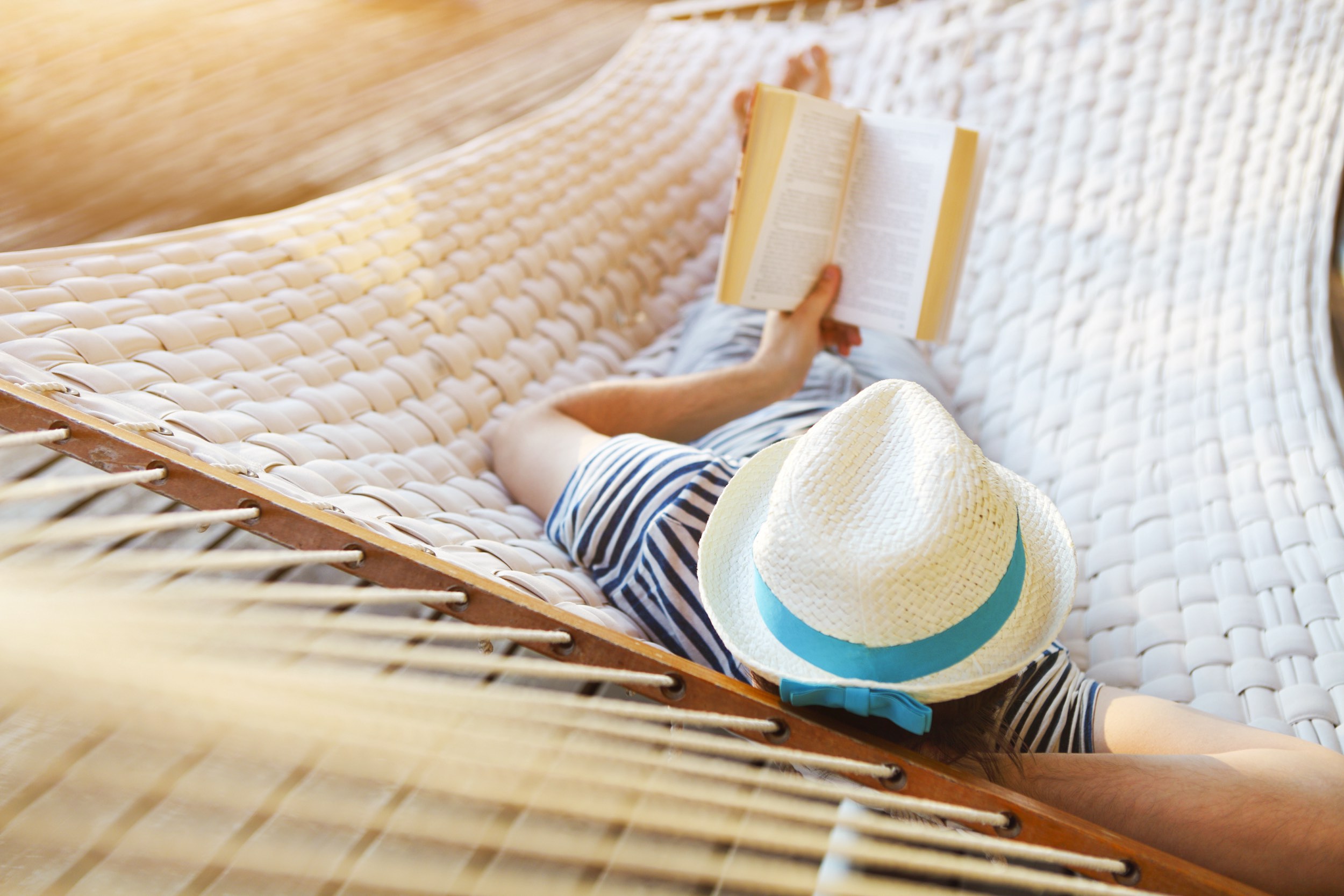 Man relaxing on a hammock with a book. Bookshop Noosa